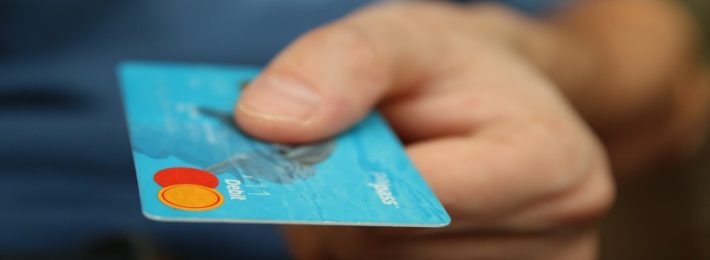 male hand holding blue debit card